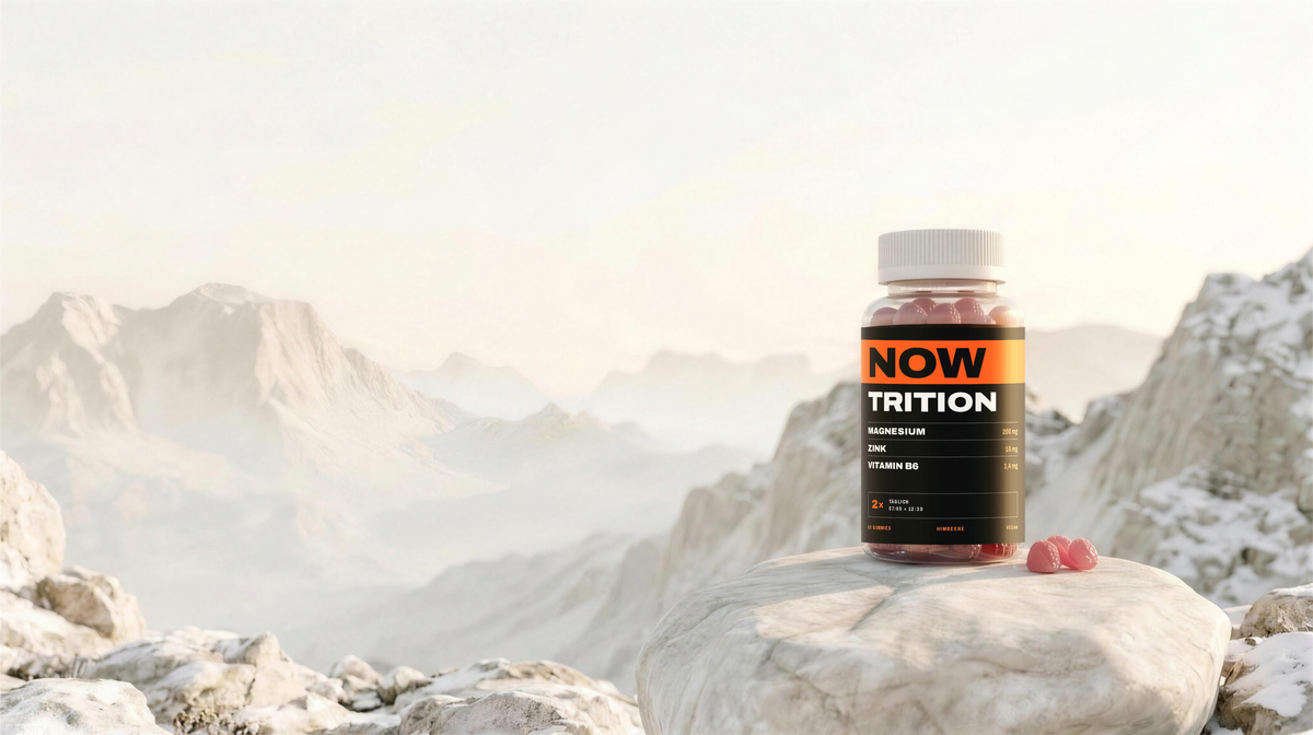 NOWTRITION Dose mit Himbeer-Gummies auf weißem Fels über den Bergen im Morgenlicht